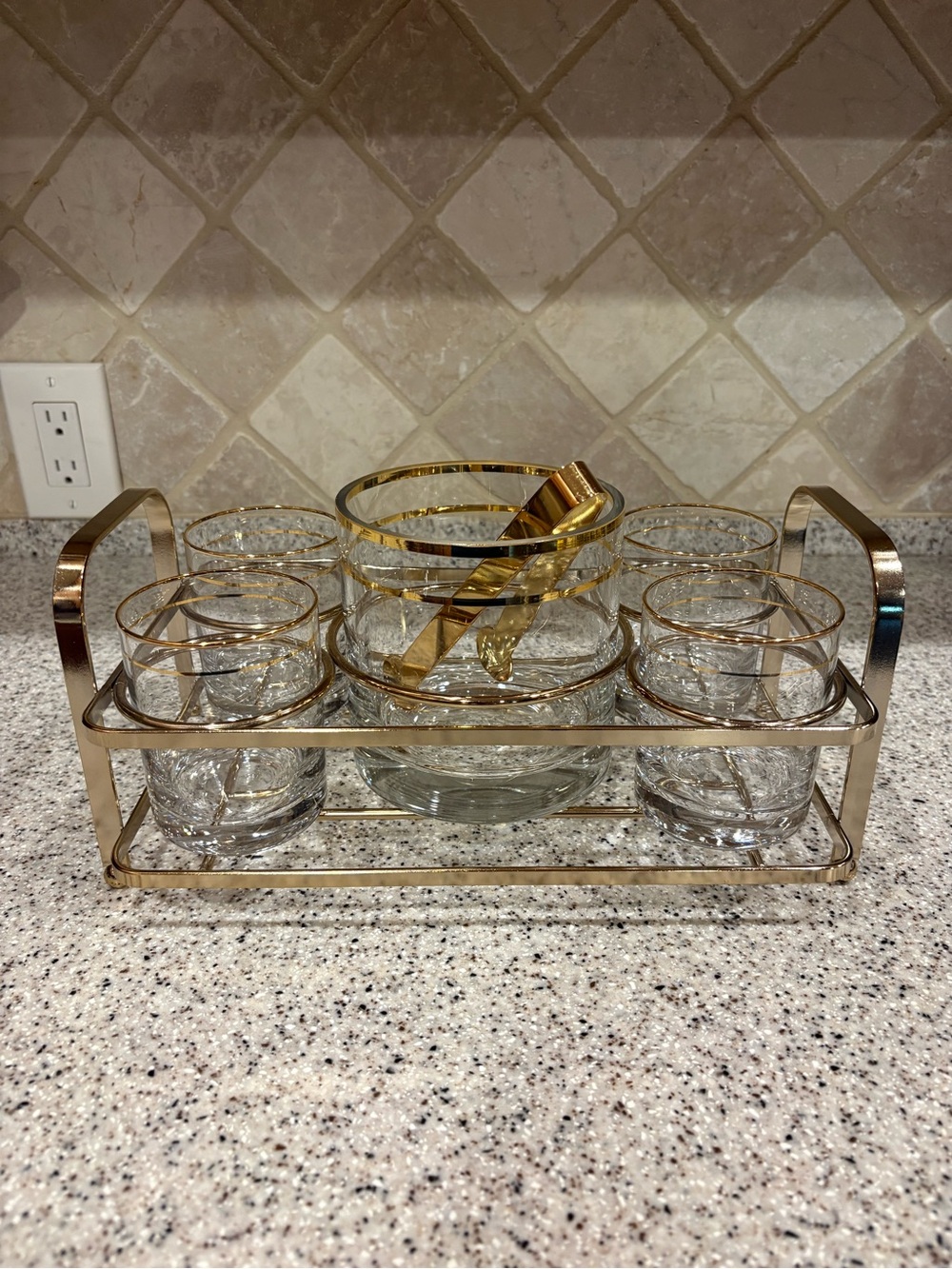 Vintage mid-century barware set featuring gold-rimmed glasses, ice Bucket, Tongs